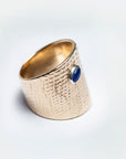 Three-quarter view of the Reptilia gold ring, bezel-set natural gemstone visible.
