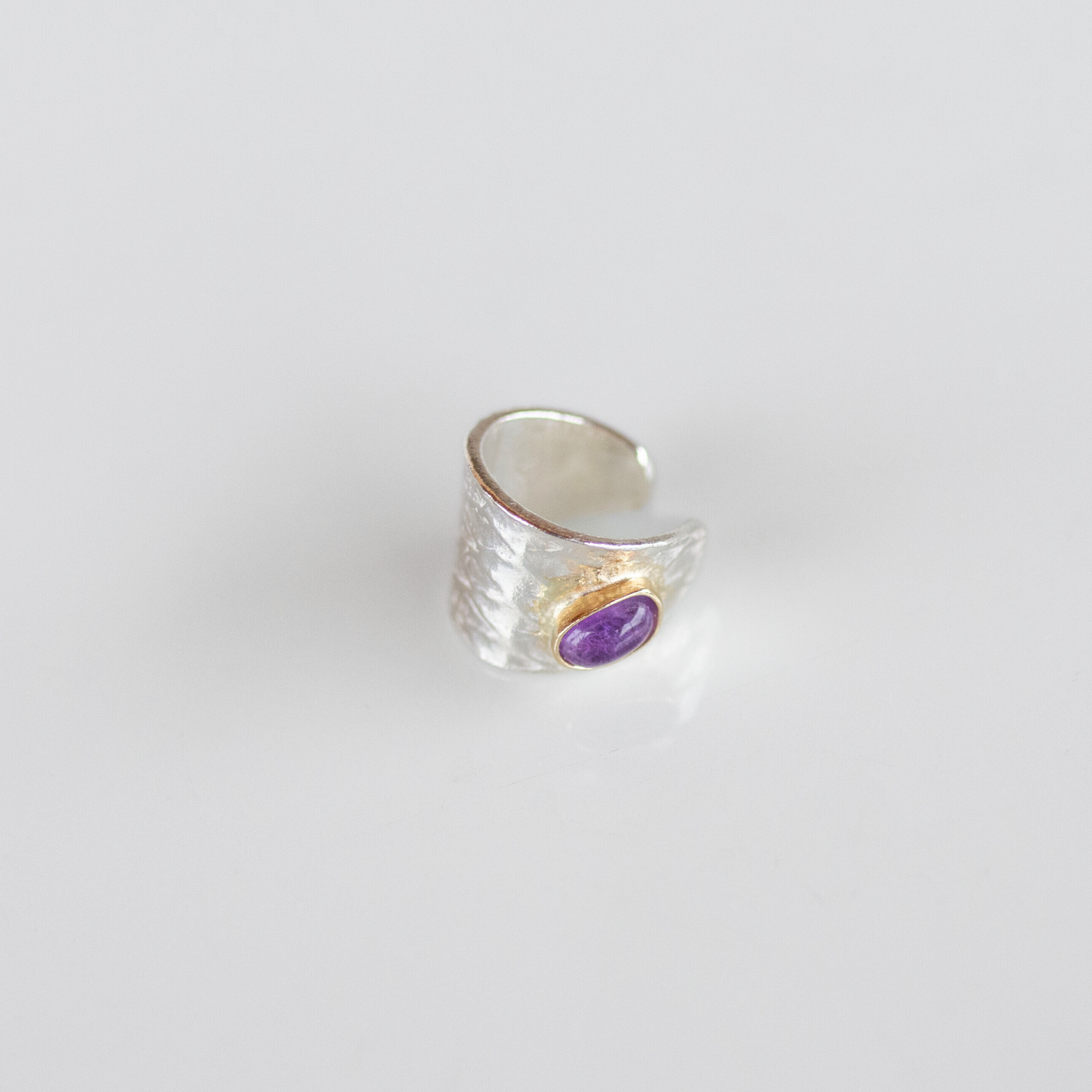 Reptilia silver earcuff with natural gemstone, serpent-inspired design detail.