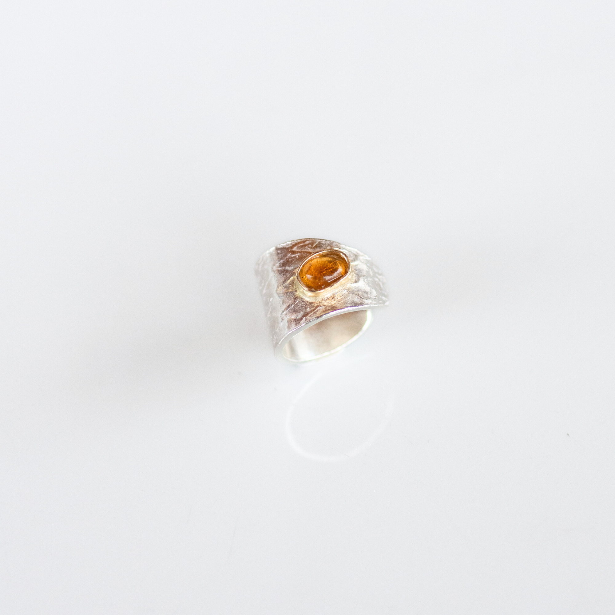 Reptilia silver earcuff with natural gemstone, serpent-inspired design detail.