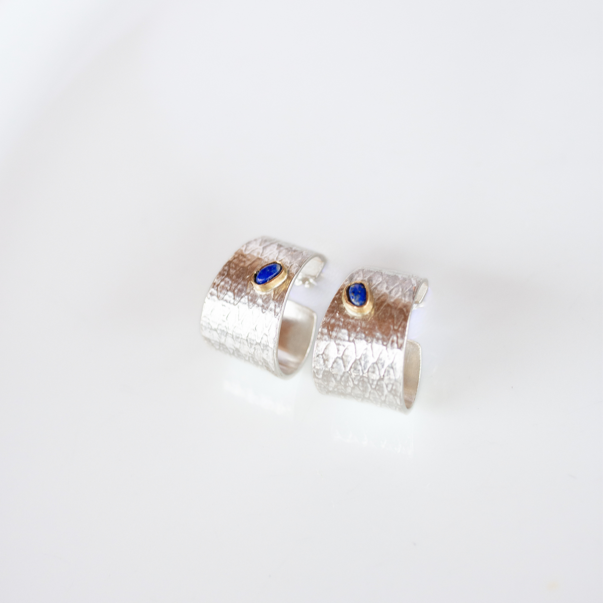 Reptilia silver textured earrings with blue natural stone (lapis lazuli), front view.