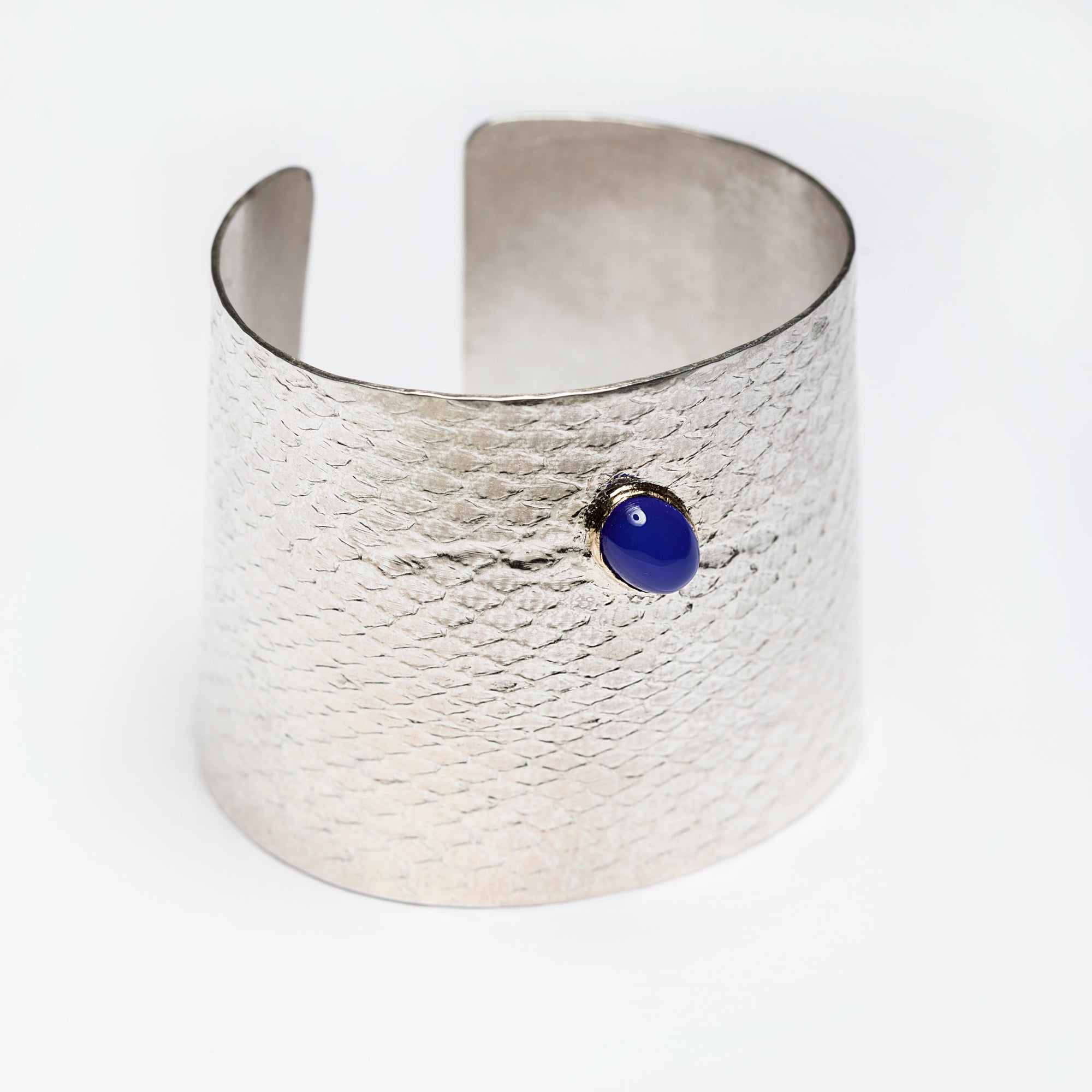 Reptilia Maxima silver cuff with blue chalcedony cabochon set in 18k gold, angled front view.