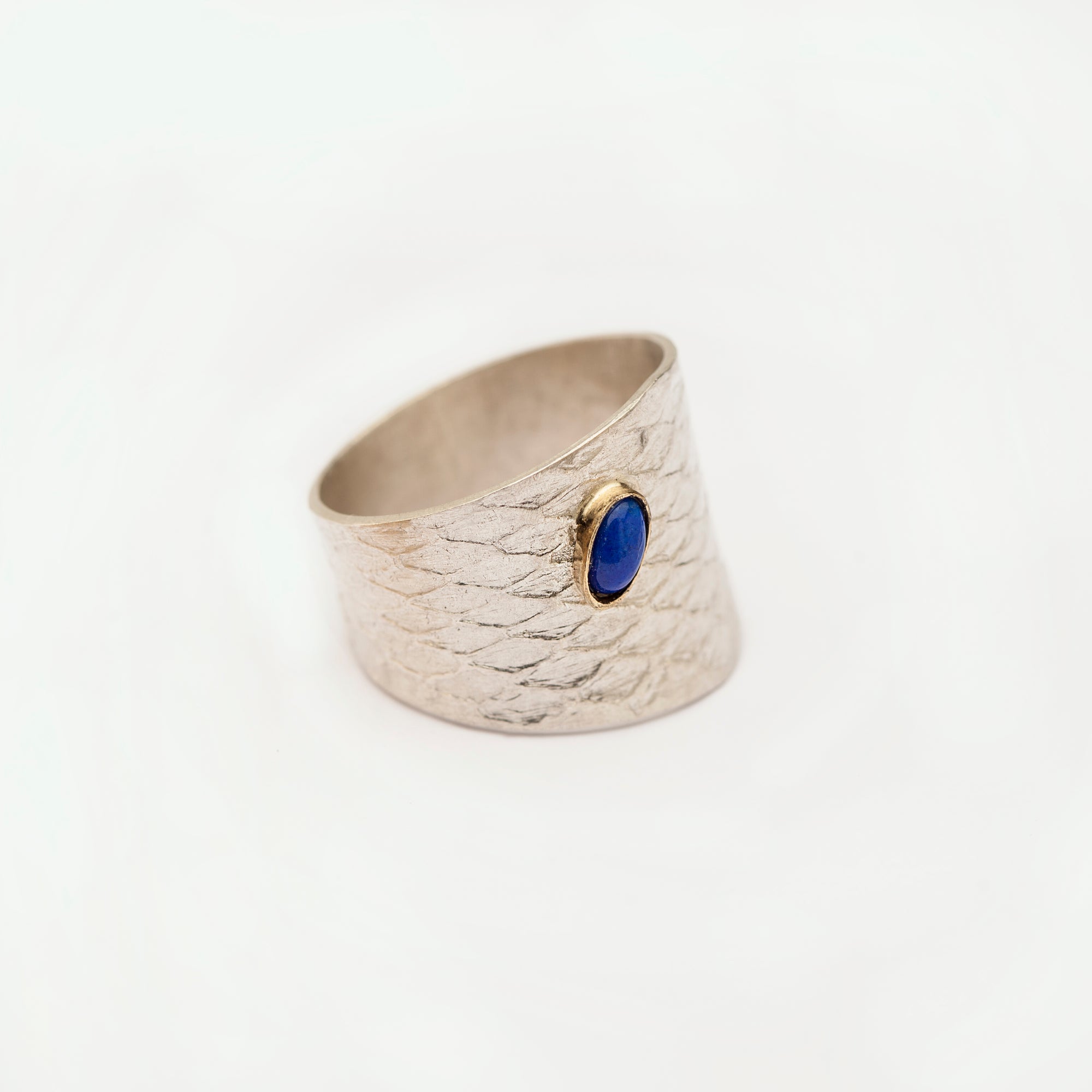 Three-quarter view showing the sculptural band of the Reptilia silver ring.